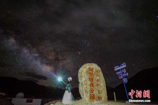 圖為6月20日晚，游客“打卡”西藏阿里暗夜公園，天上是銀河與流星（右上角）。曹枝清 攝