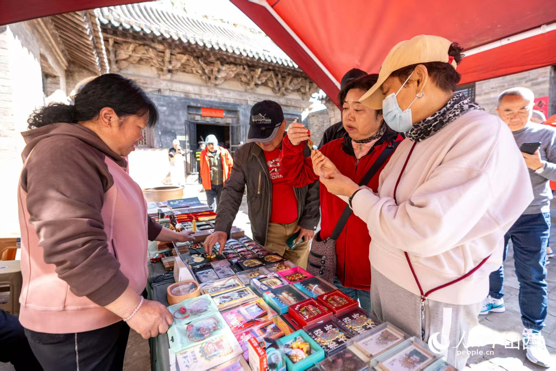 游客在山西省高平市鐵佛寺選購(gòu)文創(chuàng)產(chǎn)品。人民網(wǎng)記者 盧鵬宇攝