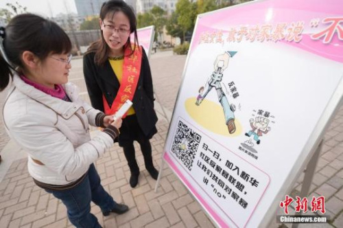 資料圖：今年3月8日，安徽合肥新華社區(qū)志愿者夏一瓊(右)向市民普及反家暴相關法律知識。鐘欣 攝