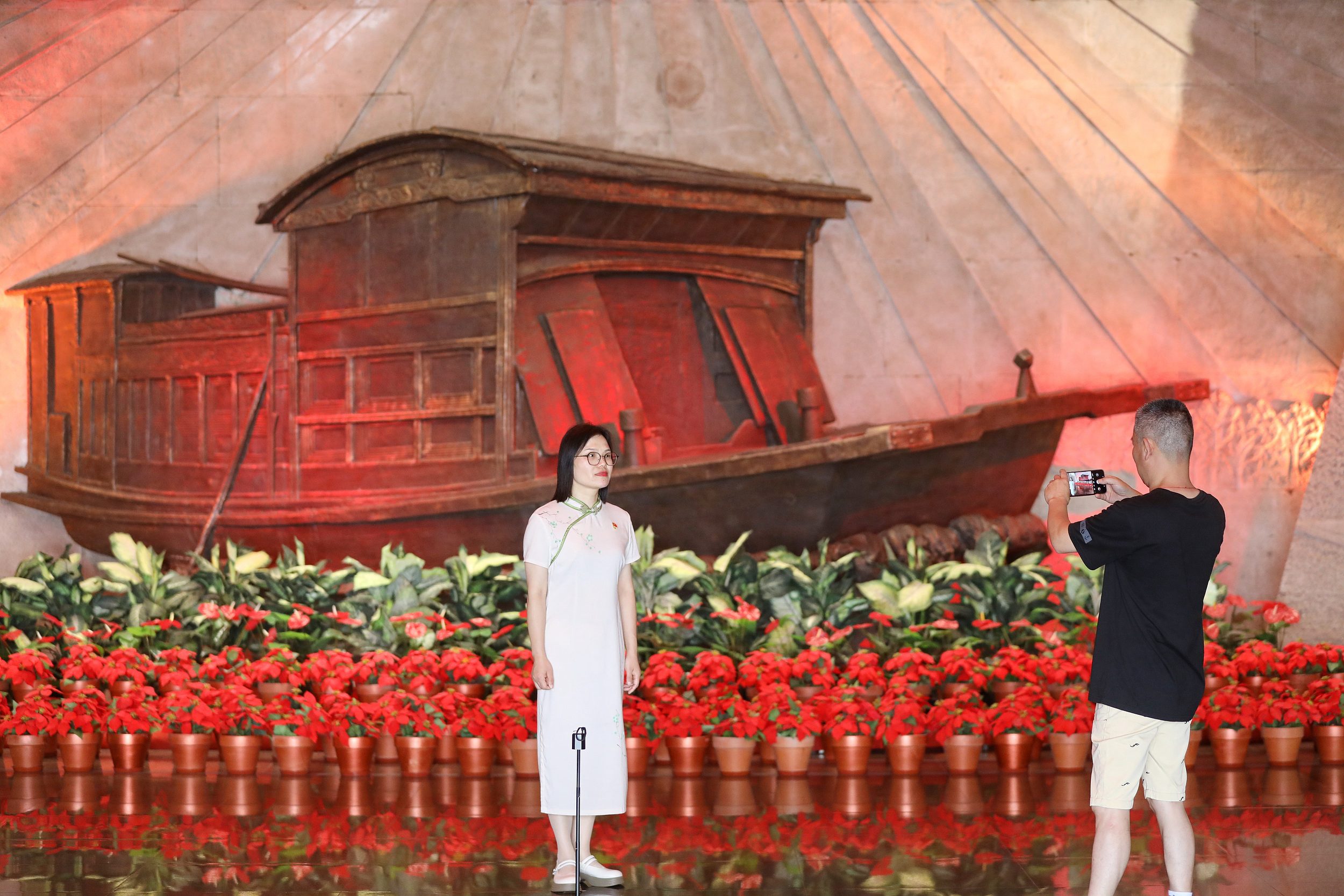 2025年6月24日，浙江嘉興，游客在南湖革命紀念館與紅船雕塑合影。（圖片來源：視覺中國）