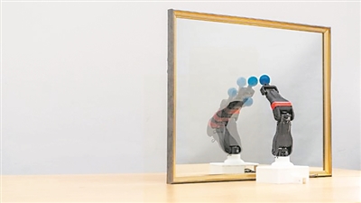  圖為機器人觀察自己在鏡子中的倒影，學習自身的形態(tài)和運動學，實現(xiàn)自主模擬。圖片來源：美國哥倫比亞大學