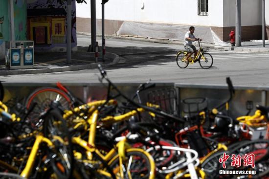 上?，F(xiàn)共享單車“墳?zāi)埂?堆積如山場面壯觀。 張亨偉 攝
